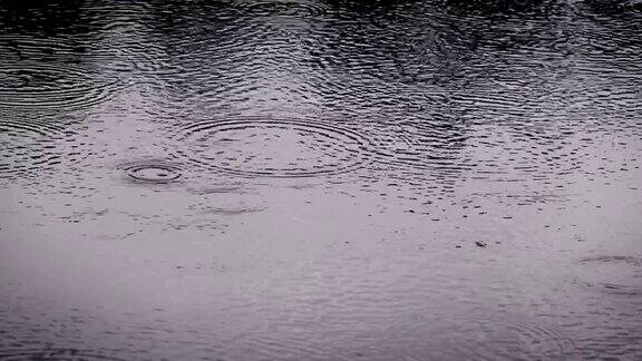 在雨季近距离拍摄的雨滴落到河面的暗色调4KDci分辨率