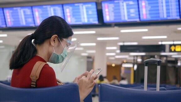 亚洲女性在乘飞机旅行时戴口罩和面罩来保护自己