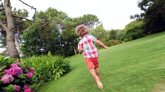 小男孩在自家后院的花园里奔跑