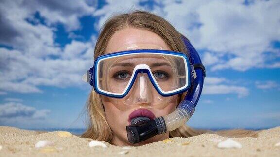 一个女人带着通气管被埋在沙滩上的沙子里