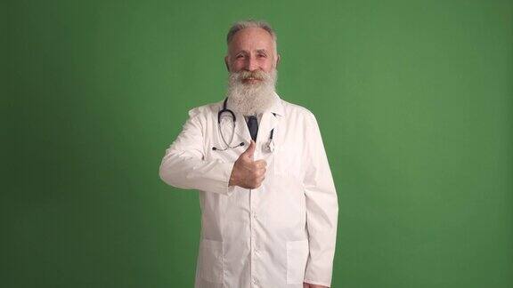 穿白大褂的成熟医生竖起大拇指绿色背景