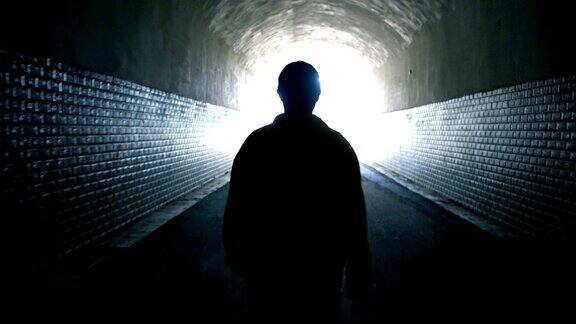 一个女人在黑暗的隧道里走向光明