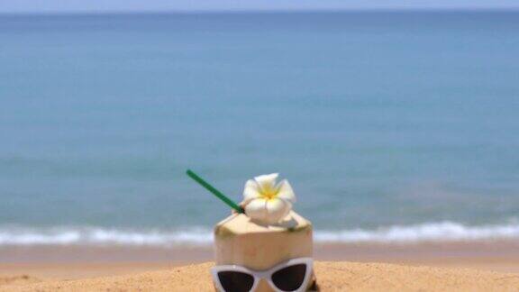 新鲜的椰子汁和热带海滩上的太阳镜