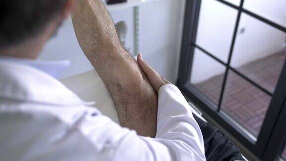 理疗师正在检查病人腿的疼痛部位