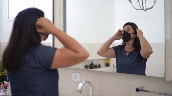 成熟的女人在浴室里戴上防护面具