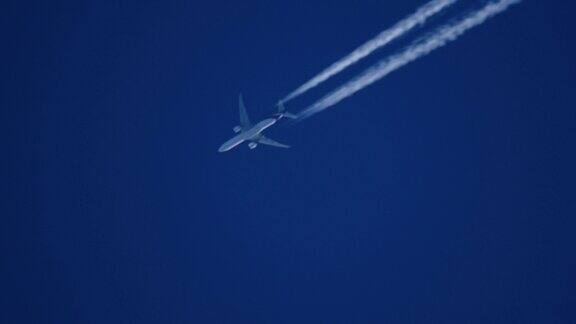 蓝色天空中尾迹处于巡航高度的喷气式飞机