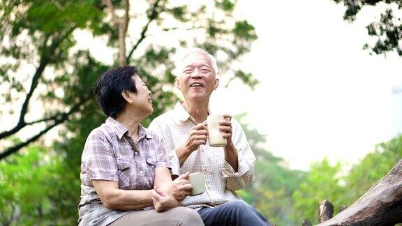 快乐的老亚洲老夫妇在公园约会早上咖啡的谈话