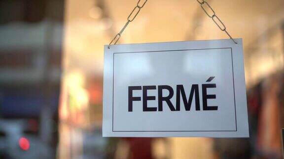关门标志(fermé)透过玻璃看到的商店