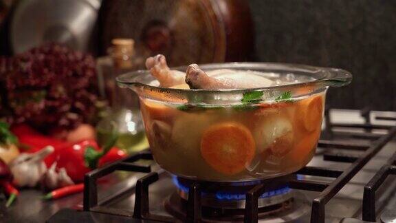 在煤气炉上的透明炖锅里煮鸡肉摄影摄影