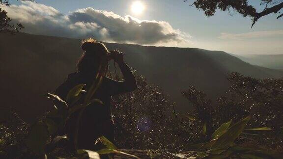 女子站在山顶欣赏日落美景的慢镜头