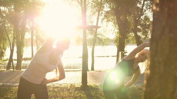 两个年轻迷人的女人与马尾辫运动在公园减肥镜头光晕和美丽的背景
