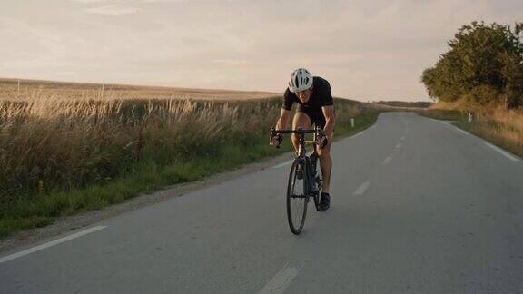 SLOMO职业自行车手在日落时分骑着自行车穿过乡村