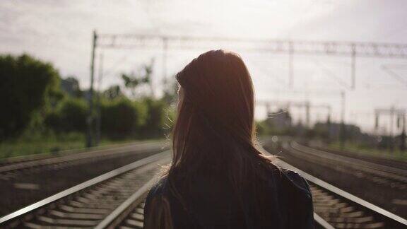 一个年轻女子在铁路上走了