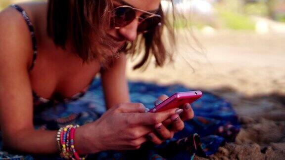快乐的年轻女子在沙滩上发短信