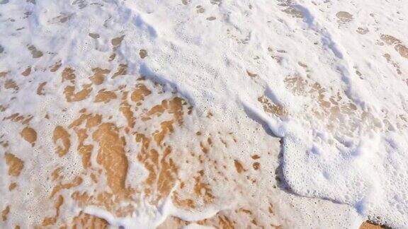 海浪卷起白色沙滩的特写镜头