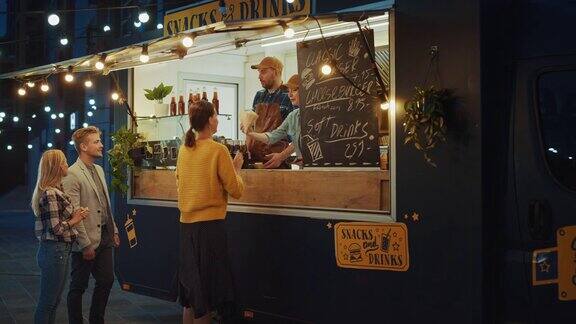 快餐车员工向快乐的年轻嬉皮士顾客分发新鲜制作的牛肉汉堡、薯条和冷饮一辆商业卡车在一个现代酷的街区卖街头食品