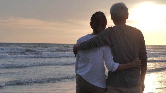 一对老年夫妇在海边放松的剪影老年假期假期退休度假概念快乐成熟的退休夫妇享受美丽的日落在海滩老年夫妇在慢镜头假期iStock