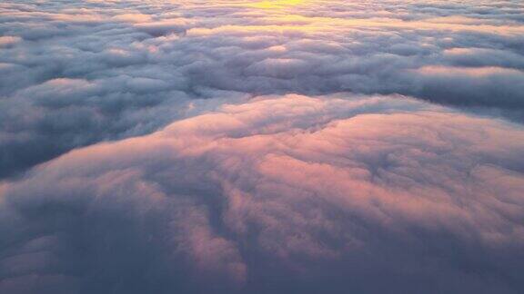 从高空的飞机窗口鸟瞰密集的蓬松的积云在傍晚飞行