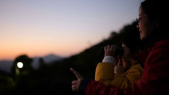 母子俩用望远镜看风景