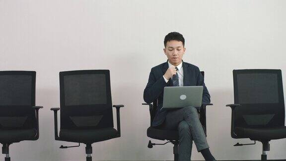 年轻的亚洲求职者坐在椅子上等待面试