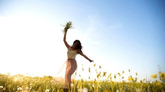 快乐的女人在春天的草地上旋转
