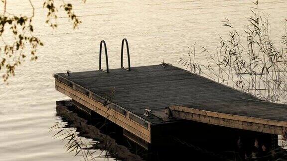 夕阳西下时芬兰宁静的湖面上的小木码头