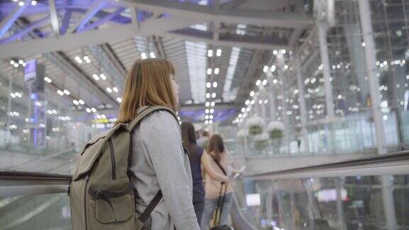 年轻的亚洲女背包客在国际机场散步