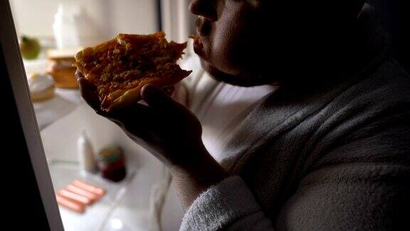 没有动机的肥胖单身汉晚上在冰箱旁边吃披萨节食失败