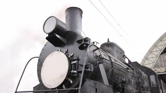 复古蒸汽火车从火车站出发老式黑色蒸汽火车车厢是蓝色的