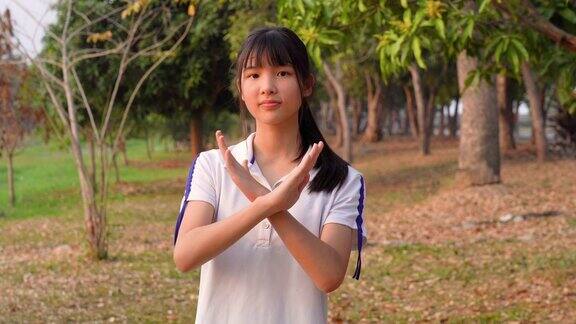亚洲年轻女子的面部表情拟人化的笑脸拒绝手势