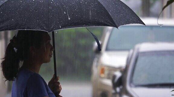 SLOMO女人站在城市街道在雨天
