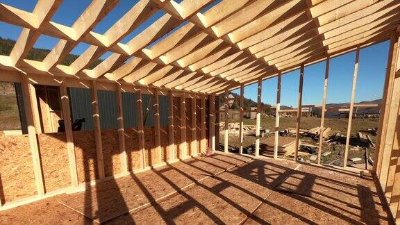 木匠将OSB面板安装在未来木制框架小屋的墙上