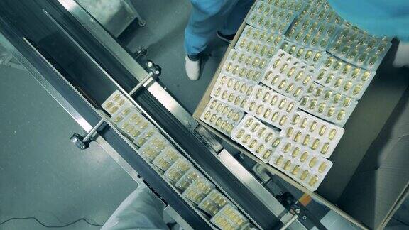 制药学、制药概念化工工人正在把泡好的胶囊装进盒子里