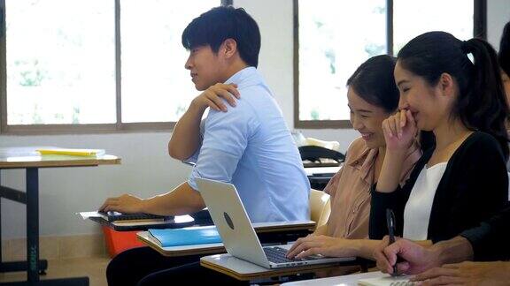 年轻的亚洲疲惫的学生男人睡在教室里学习教育和学校