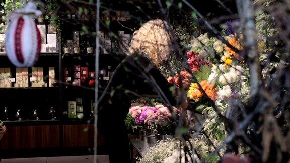 一个卖花的女人把一瓶花放在架子上