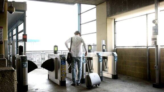 休闲商人在地铁车站滚动行李