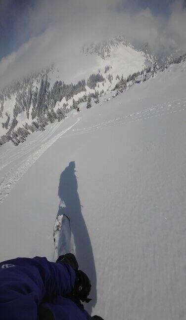 滑雪板运动员从崭新的雪山上滑下俯瞰山下的阿尔卑斯山