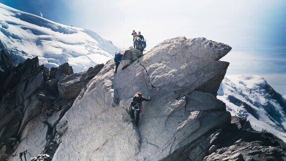 一队登山者正在攀登陡峭的山峰冬季高山探险