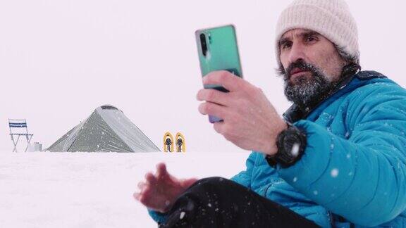成熟的游客在冬季山地露营时使用手机独自在大自然中