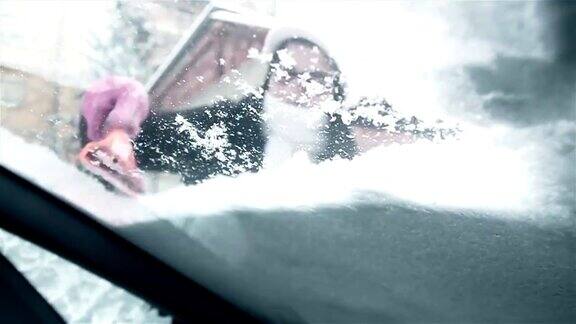 正在清理汽车挡风玻璃上的雪的女人