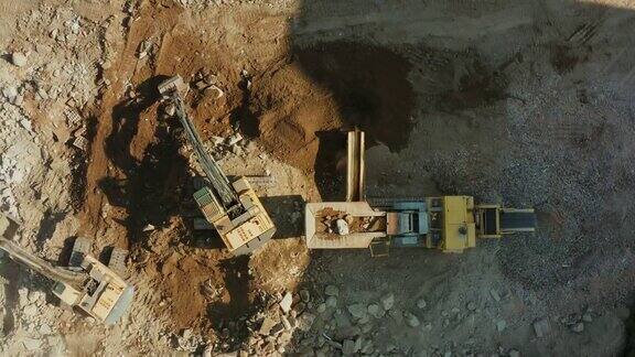 两台挖掘机从上到下挖掘地面将大块岩石破碎并将岩石装载到破碎厂加工成碎石