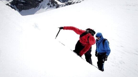 登山者爬上白雪覆盖的山