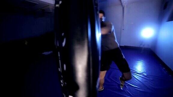 年轻拳击手在拳击袋里踢腿摄像机稳定拍摄