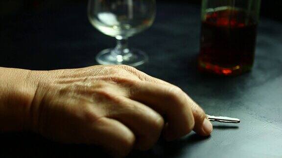 一个男人在酒吧喝威士忌从桌子上拿车钥匙