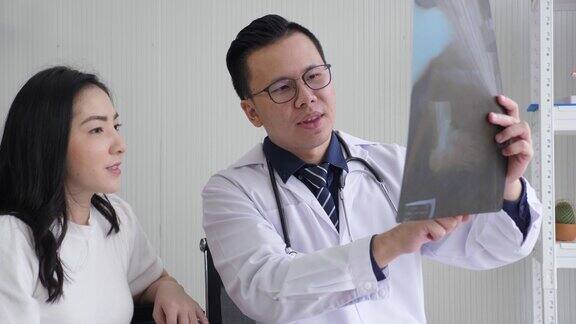 亚洲男医生向女病人解释x光检查结果