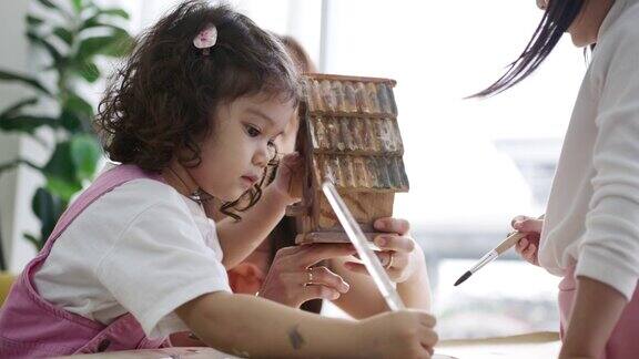 亚洲家庭妈妈教女孩画木房子