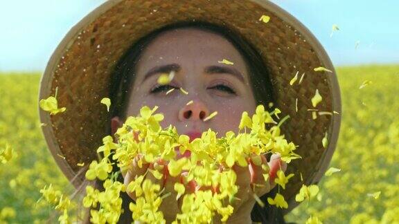 一名年轻女子在乡村吹花瓣的4k视频片段