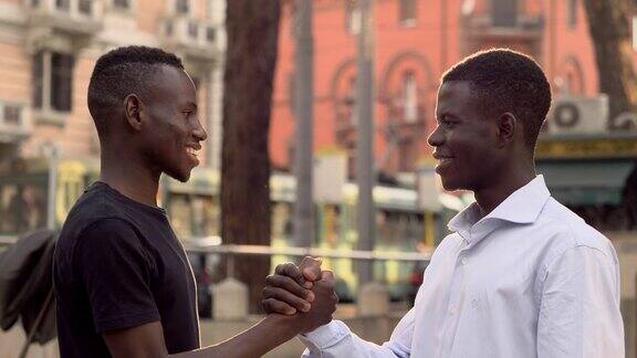 非洲青年微笑着在大街上互相问候友谊、种族