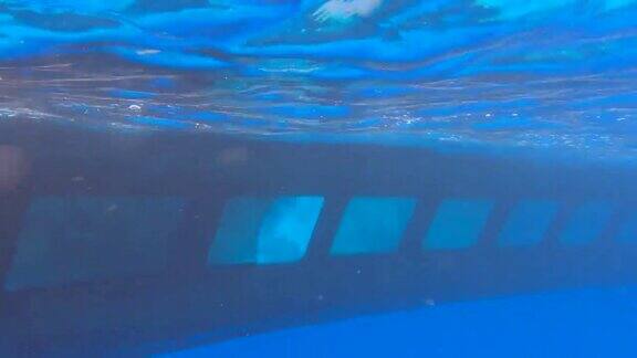 潜水器潜艇上的游客游泳附近的珊瑚礁在蓝色的水黄色潜水艇漂浮在蓝色的水中人们通过舷窗观看水下世界