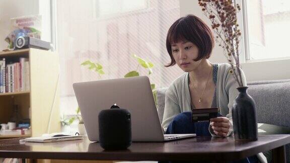 年轻的日本女性成年人用信用卡在网上购物